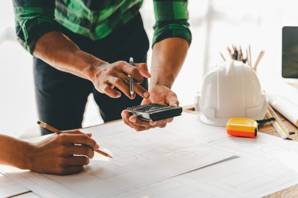 engineers-work-as-a-team-with-blueprints-for-archi-2023-11-27-04-56-49-utc-scaled